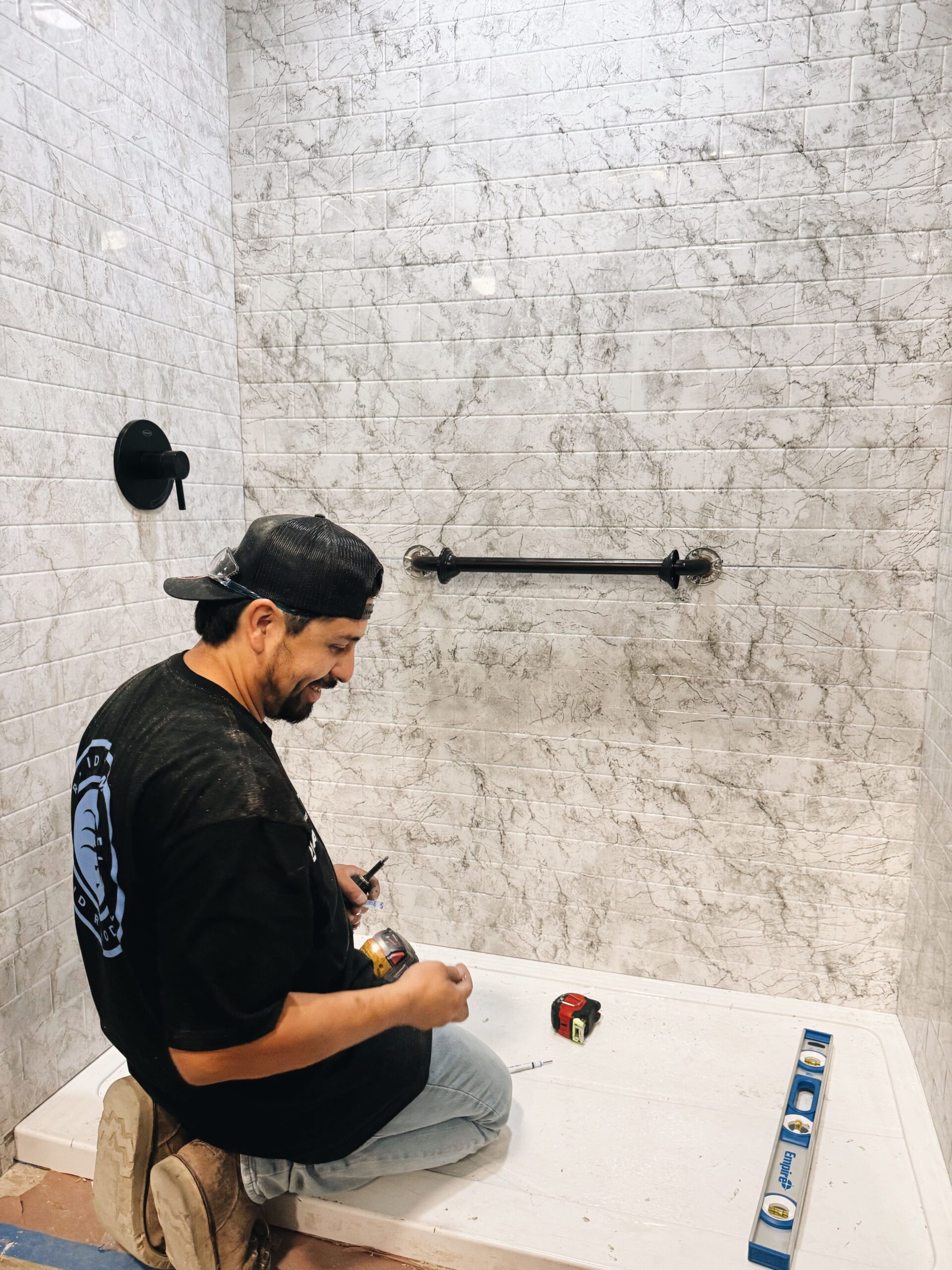 Rapid Remodel contractor installing shower tile and fixtures for a bathroom remodel