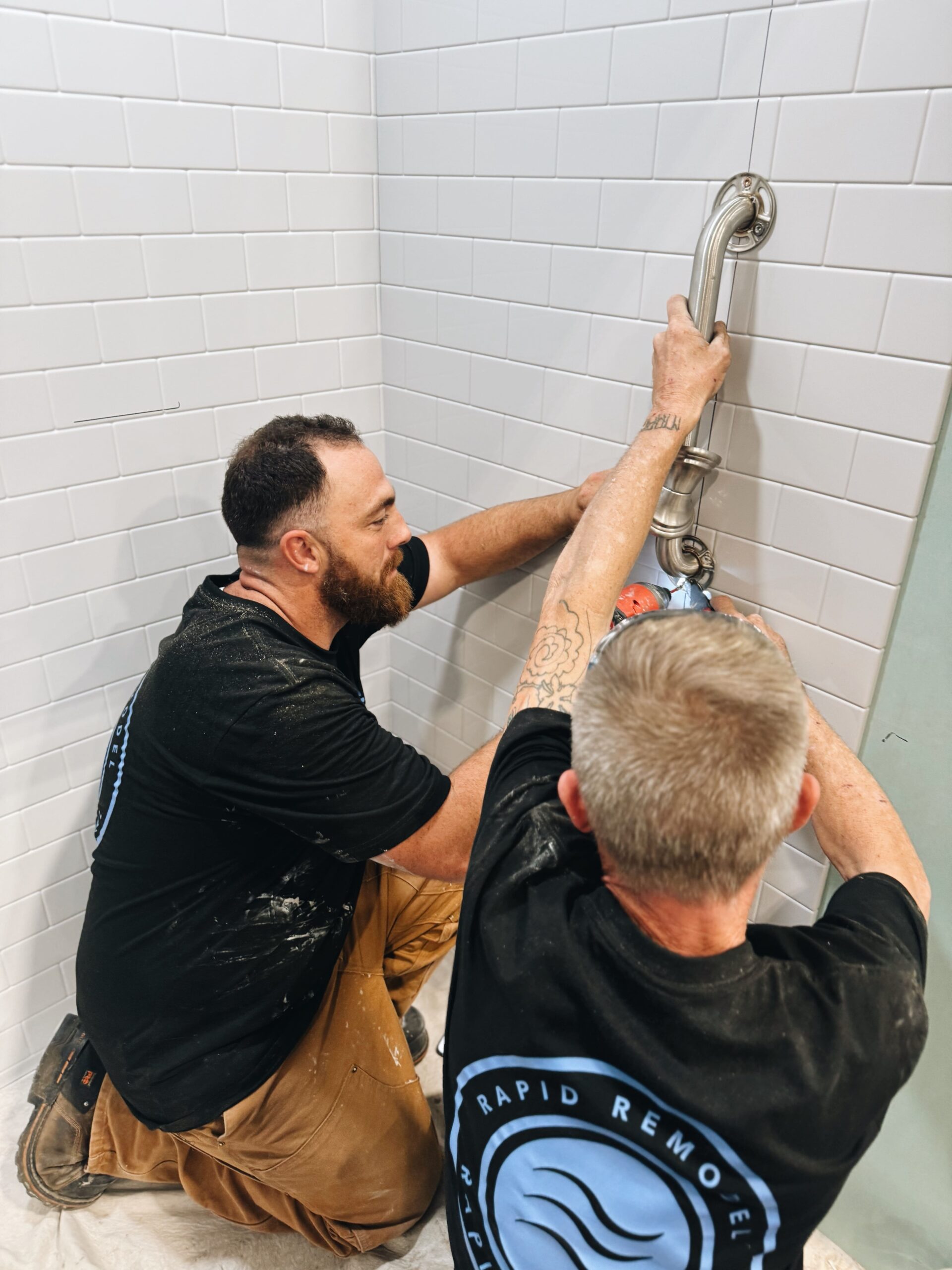Rapid Remodel team installing a shower grab bar during a bathroom remodeling project
