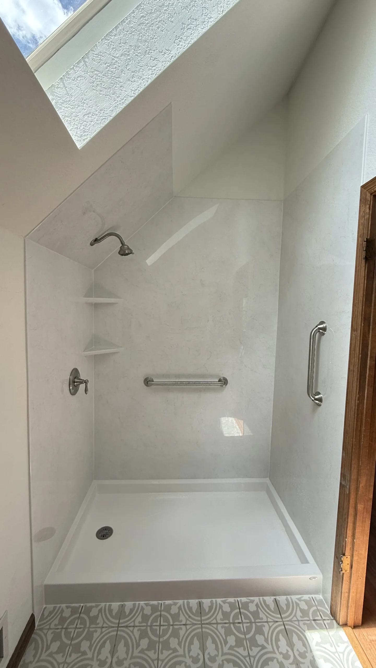 Newly remodeled walk-in shower with white tile walls and black shower fixtures