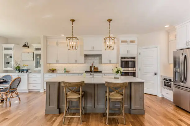 Designer evaluating kitchen layout, lighting, and cabinet spacing with detailed renovation plans