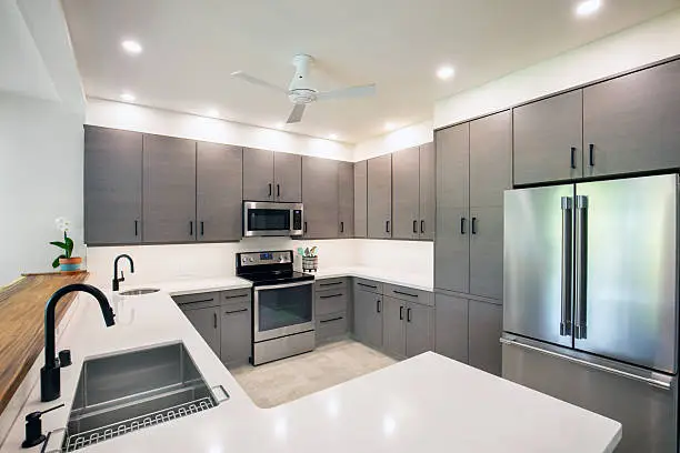Homeowner reviewing sleek cabinet and island plans during active kitchen renovation project