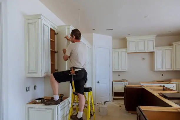 Kitchen designer assessing lighting, storage, and workflow for efficient modern renovation plan
