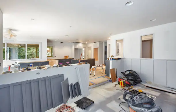 Designer reviewing premium cabinetry and stone countertop selections for upscale kitchen renovation